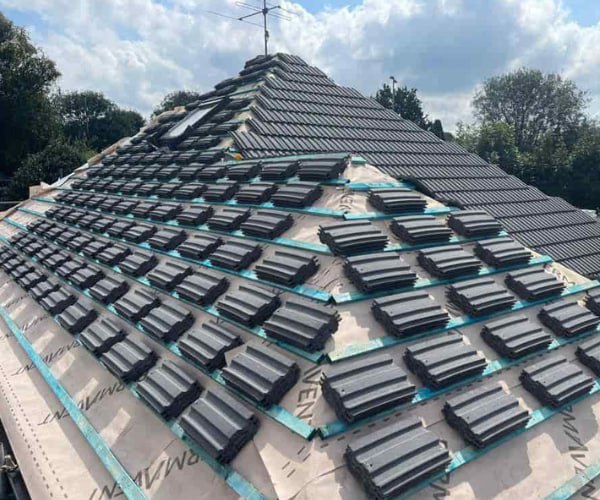 This is a photo of a new hip roof being installed. New felt, battens, and grey tiles have been installed, also a new velux window. Works carried out by ES Roofing Adwick Le Street